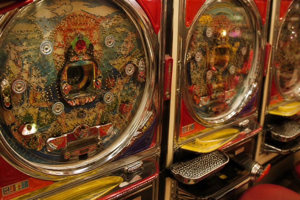 Zbliżenie na automaty pachinko ze szklaną tarczą i tackami na kulki